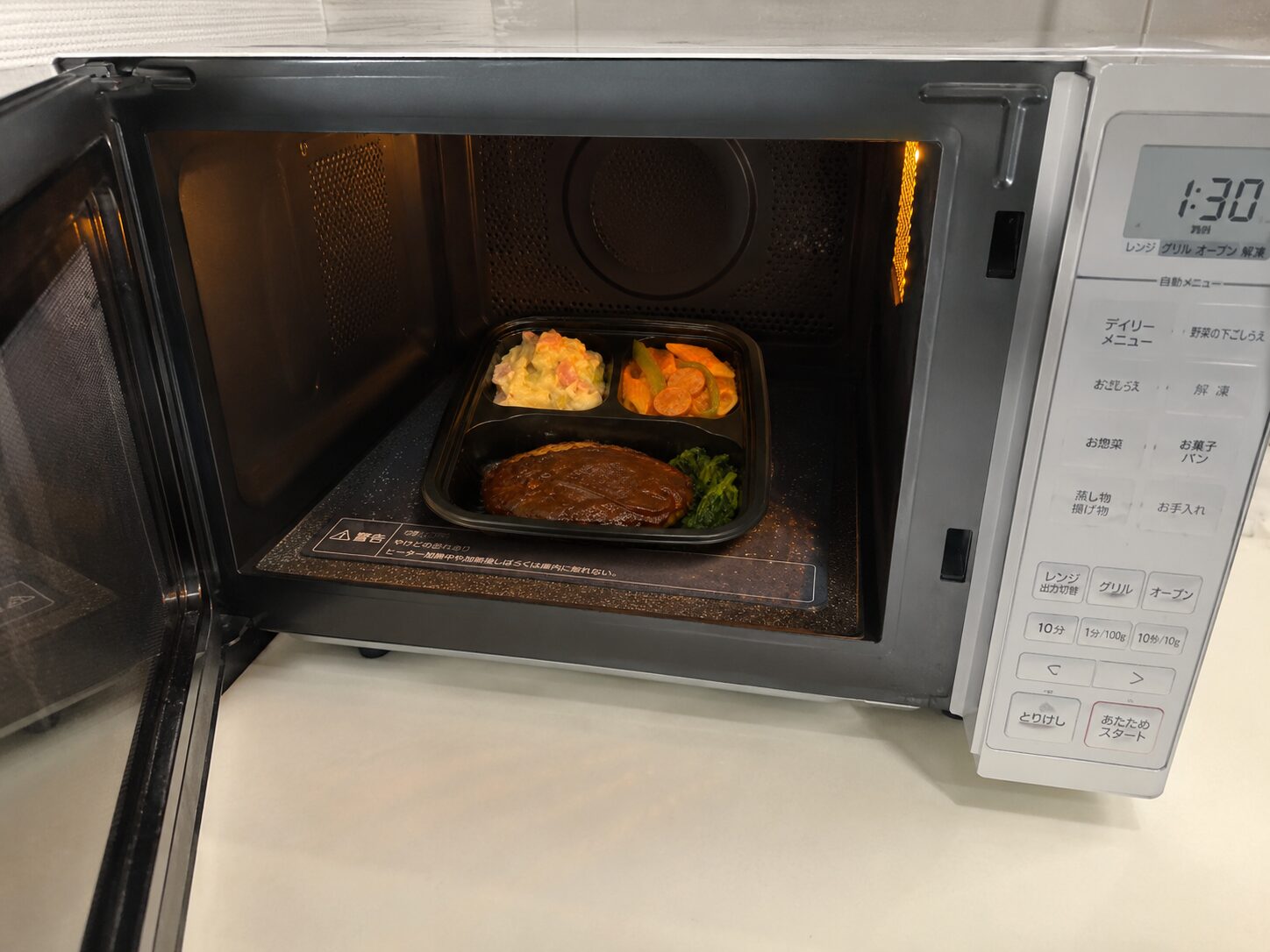 【実食写真⑤:電子レンジに入れて加熱している最中の写真、または空になった容器を捨てる際の写真】